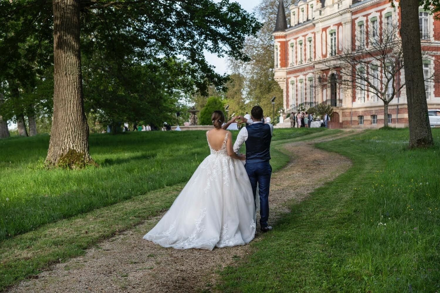 Couple de maries qui marche dans le parc du chateau Laverdines